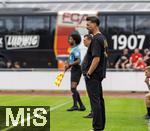 25.07.2025, Fussball 1. Bundesliga 2025/2026,  Testspiel Rot-Weiss Essen - FC Augsburg, im Donaustadion Dillingen, Schwaben. Trainer Sandro Wagner (FC Augsburg) am Spielfeldrand. Im Hintergrund Trainer Uwe Koschinat (Essen), durch den Blickwinkel knnte man meinen, Wagner hat neuerdings eine Wohlstandsplauze.
 

