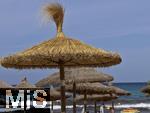 23.07.2025,  Beliebtes Reiseziel der Deutschen, Mallorca. Hier Cala Ratjada am Strand Cala Agulla. Die traditionellen Sonnenschirme aus Stroh.