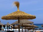 23.07.2025,  Beliebtes Reiseziel der Deutschen, Mallorca. Hier Cala Ratjada am Strand Cala Agulla. Die traditionellen Sonnenschirme aus Stroh.