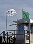 23.07.2025,  Beliebtes Reiseziel der Deutschen, Mallorca. Hier Cala Ratjada am Strand Cala Agulla. Die Weisse Flagge mit Quallen-Aufdruck steht am Strand, das soll eine Warnung vor den unangenehmen Feuerquallen im Wasser sein.