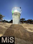 23.07.2025,  Beliebtes Reiseziel der Deutschen, Mallorca. Hier Cala Ratjada am Strand Cala Agulla. Getrnkebecher aus Plastik mit Gin-Tonic steht im Sand.