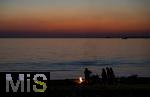 09.08.2025, Bregenz am Bodensee, Abendrot taucht den stillen See in mystisches Licht. Am Ufer hat jemand ein Lagerfeuer entzndet.