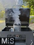 10.08.2025, Grillen bei Freunden, E>inheizen der Grillkohle mittels Kaminvorrichtung im Grill.