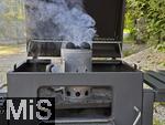 10.08.2025, Grillen bei Freunden, E>inheizen der Grillkohle mittels Kaminvorrichtung im Grill.