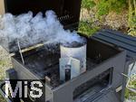 10.08.2025, Grillen bei Freunden, E>inheizen der Grillkohle mittels Kaminvorrichtung im Grill.