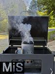10.08.2025, Grillen bei Freunden, E>inheizen der Grillkohle mittels Kaminvorrichtung im Grill.