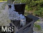 10.08.2025, Grillen bei Freunden, E>inheizen der Grillkohle mittels Kaminvorrichtung im Grill.
