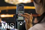 10.09.2025, Messe Mnchen IAA Mobility 2025 in Mnchen im Messegelnde Riem. Mitarbeiterin beim Live-Streaming per Handy am Stand von AITO. AITO ist eine Automarke aus der Volksrepublik China.  AITO ist die erste Marke im Rahmen von Huaweis Harmony Intelligent Mobility Alliance (HIMA). Huawei ist verantwortlich fr Produktdesign, Entwicklung und die Lieferung wichtiger Technologien wie Antriebssysteme, Fahrerassistenzsysteme und Software. 