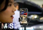 10.09.2025, Messe Mnchen IAA Mobility 2025 in Mnchen im Messegelnde Riem. Mitarbeiterin beim Live-Streaming per Handy am Stand von AITO. AITO ist eine Automarke aus der Volksrepublik China.  AITO ist die erste Marke im Rahmen von Huaweis Harmony Intelligent Mobility Alliance (HIMA). Huawei ist verantwortlich fr Produktdesign, Entwicklung und die Lieferung wichtiger Technologien wie Antriebssysteme, Fahrerassistenzsysteme und Software. 