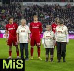 27.02.2026, Fussball 1. Bundesliga 2025/2026, 24.Spieltag, FC Augsburg - 1.FC Köln, in der WWK-Arena Augsburg. Bewohnerinnen und Bewohner der Augsburger Fuggerei laufen mit den Mannschaften aufs Spielfeld ein. Jahmai Simpson-Pusey (Köln), Rav van den Berg (1. FC Köln), Ragnar Ache (1.FC Köln) 