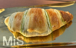 04.03.2026,  Bad Wörishofen, Ein frisches Butter Croissant mit Pistazienfüllung liegt auf einem Tablett zum Essen bereit.
