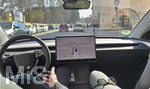 24.03.2026, München (Bayern),  Full Self-Driving (Supervised) Probefahrt mit dem Autonomen FSD-Tesla Model 3 Elektroauto ohne Fahrereingriff durch die engen Strassen der Innenstadt von München. Der Tesla fährt nur mit Kameras souverän autonom, ein Teslamitarbeiter auf dem Fahrersitz überwacht die Fahrt für eventuelle Fahrfehler. Tesla bietet Termine für Probefahrten mit Full Self-Driving (FSD) unter Aufsicht (Supervised) seit Ende November an mehreren Standorten in Deutschland an (Bildbearbeitung)