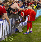 15.04.2026,  Fussball UEFA Championsleague 2025/2026: Viertelfinale Rückspiel,  FC Bayern München - Real Madrid, in der Allianz-Arena München, Frenetischer Schlussjubel bei den Bayern nach dem 4:3 Siegtreffer, Fans drängen an die Bande, die teilweise zerbricht, ein besorgter Alphonso Davies (FC Bayern München) versucht die ausgebrochenen LED-Panele fachmännisch wieder zu montieren.