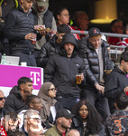 19.04.2026, Fussball Bundesliga 2025/2026, 30.Spieltag, FC Bayern München - VfB Stuttgart, in der Allianz-Arena München, der derzeit verletzte Lennart Karl (mitte, FC Bayern München) auf der Tribüne mit Jogging-Hose des Designerlabels CHROME HEARTS und Anorack von Prada.
