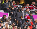 19.04.2026, Fussball Bundesliga 2025/2026, 30.Spieltag, FC Bayern München - VfB Stuttgart, in der Allianz-Arena München, der derzeit verletzte Lennart Karl (mitte, FC Bayern München) auf der Tribüne mit Jogging-Hose des Designerlabels CHROME HEARTS und Anorack von Prada.