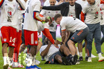 19.04.2026, Fussball Bundesliga 2025/2026, 30.Spieltag, FC Bayern München - VfB Stuttgart, in der Allianz-Arena München, die Spieler feiern nach dem Sieg die 35. Deutsche Meisterschaft. Die Mannschaft feiert mit den Fans und speziellen Meistertrikots mit Aufdruck des kultigen Porzellan-Kakadus mit Meisterschale. Co-Trainer Rodyse Munienge (am Boden, FCB) wird von seinen Kameraden vom Staff getriezt, er nimmt es mit Humor.
