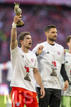 19.04.2026, Fussball Bundesliga 2025/2026, 30.Spieltag, FC Bayern München - VfB Stuttgart, in der Allianz-Arena München, die Spieler feiern nach dem Sieg die 35. Deutsche Meisterschaft. Die Mannschaft feiert mit den Fans und speziellen Meistertrikots mit Aufdruck des kultigen Porzellan-Kakadus mit Meisterschale. Leon Goretzka (FC Bayern München) mit der Porzellanfigur in der Hand. v.li: Torwart Sven Ulreich (FC Bayern München)  