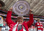 19.04.2026, Fussball Bundesliga 2025/2026, 30.Spieltag, FC Bayern München - VfB Stuttgart, in der Allianz-Arena München, die Spieler feiern nach dem Sieg die 35. Deutsche Meisterschaft. Auch Edelfan Erika Lapp (Fanclub Ebsdorf) hält eine Kopie der Meisterschale hoch. 