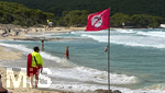 16.05.2026, Reiseziel Insel Mallorca (Spanien). Cala Ratjada, am Strand der Cala Agulla. Die Flagge mit Badeverbotsteht am Strand, das heisst für die Badegäste eine Warnung vor zu gefährlicher Strömung im Meer. Ein Rettungsschwimmer passt auf.