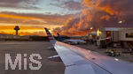 16.05.2026, Reiseziel Insel Mallorca (Spanien). Cala Ratjada, Airport Palma de Mallorca, Blick aus dem Flugzeugfenster einer Condor-Maschine zum Abfluggate mit den Maschinen zur Abfertigung, ein spektakulärer Sonnenuntergang mit Wolkenstimmung, links der Tower der Fluglotsen.