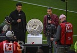 16.05.2026, Fussball Bundesliga 2025/2026, 34.Spieltag, FC Bayern München - 1.FC Köln, in der Allianz-Arena München,   Die Meisterschale im Detail neben Michael Ballack und Laura Wontorra (beide Deutschland).


