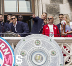 17.05.2026, Fussball Bundesliga 2025/2026, Meisterfeier des FC Bayern München auf dem Rathausbalkon in München.  Leon Goretzka (FC Bayern München) mit der Meisterschale. re: Torwart Manuel Neuer (FC Bayern München) deutet neben Moderator Stephan Lehmann mit dem Finger auf etwas im Publikum, danach gibt Lehmann eine Durchsage, das Bayern-Banner das 1860-Ultras eingeschmuggelt hatten zu entfernen. (auf dem Bayern-Logo steht FC Bauern Hurensöhne, nicht im Bild) Ein Eklat während der Ehrung.