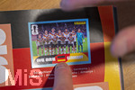 13.06.2026, Mindelheim (Bayern), das beliebte Sammelheft und die dazugehörigen Sammelbilder gibt es auch wieder zur Fussball-WM 2026 in den USA.  Ein Kind klebt Bildchen der deutschen Spieler ins Album ein. Hier das Mannschaftsfoto Deutschland 