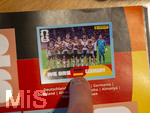 13.06.2026, Mindelheim (Bayern), das beliebte Sammelheft und die dazugehörigen Sammelbilder gibt es auch wieder zur Fussball-WM 2026 in den USA.  Ein Kind klebt Bildchen der deutschen Spieler ins Album ein. Hier das Mannschaftsfoto Deutschland 