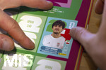 13.06.2026, Mindelheim (Bayern), das beliebte Sammelheft und die dazugehörigen Sammelbilder gibt es auch wieder zur Fussball-WM 2026 in den USA. Kind klebt Bildchen von Sardar Azmoun (Iran) ein