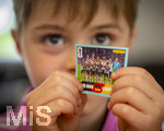 13.06.2026, Mindelheim (Bayern), das beliebte Sammelheft und die dazugehörigen Sammelbilder gibt es auch wieder zur Fussball-WM 2026 in den USA.  Der kleine Fussballfan Jakob klebt Bildchen der Spieler ins Album ein, hier hat er das Mannschaftsfoto der Deutschen Nationalmannschaft. (Modelreleased)