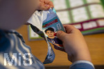 13.06.2026, Mindelheim (Bayern), das beliebte Sammelheft und die dazugehörigen Sammelbilder gibt es auch wieder zur Fussball-WM 2026 in den USA.  Der kleine Fussballfan Felix reisst eine Packung Bildchen auf. (Modelreleased)