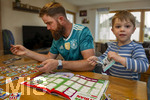 13.06.2026, Mindelheim (Bayern), das beliebte Sammelheft und die dazugehörigen Sammelbilder gibt es auch wieder zur Fussball-WM 2026 in den USA.  Der kleine Fussballfan Felix klebt mit Papa Daniel Bildchen der Spieler ins Album ein. (Modelreleased)