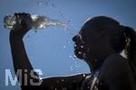 24.06.2026, Sommerhitze in Deutschland, Mindelheim im Unterallgäu, eine Frau erfrischt sich mit einem schwall kaltem Wasser in ihr Gesicht. (Modelrelased)  