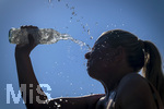 24.06.2026, Sommerhitze in Deutschland, Mindelheim im Unterallgäu, eine Frau erfrischt sich mit einem schwall kaltem Wasser in ihr Gesicht. (Modelrelased)  