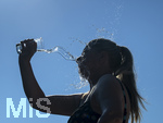 24.06.2026, Sommerhitze in Deutschland, Mindelheim im Unterallgäu, eine Frau erfrischt sich mit einem schwall kaltem Wasser in ihr Gesicht. (Modelrelased)  