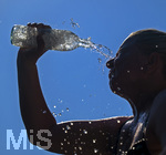 24.06.2026, Sommerhitze in Deutschland, Mindelheim im Unterallgäu, eine Frau erfrischt sich mit einem schwall kaltem Wasser in ihr Gesicht. (Modelrelased)  