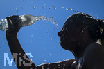24.06.2026, Sommerhitze in Deutschland, Mindelheim im Unterallgäu, eine Frau erfrischt sich mit einem schwall kaltem Wasser in ihr Gesicht. (Modelrelased)  