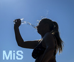 24.06.2026, Sommerhitze in Deutschland, Mindelheim im Unterallgäu, eine Frau erfrischt sich mit einem schwall kaltem Wasser in ihr Gesicht. (Modelrelased)  