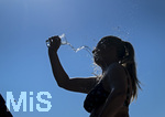 24.06.2026, Sommerhitze in Deutschland, Mindelheim im Unterallgäu, eine Frau erfrischt sich mit einem schwall kaltem Wasser in ihr Gesicht. (Modelrelased)  