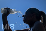 24.06.2026, Sommerhitze in Deutschland, Mindelheim im Unterallgäu, eine Frau erfrischt sich mit einem schwall kaltem Wasser in ihr Gesicht. (Modelrelased)  