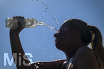 24.06.2026, Sommerhitze in Deutschland, Mindelheim im Unterallgäu, eine Frau erfrischt sich mit einem schwall kaltem Wasser in ihr Gesicht. (Modelrelased)  