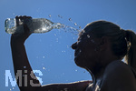 24.06.2026, Sommerhitze in Deutschland, Mindelheim im Unterallgäu, eine Frau erfrischt sich mit einem schwall kaltem Wasser in ihr Gesicht. (Modelrelased)  