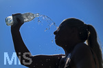 24.06.2026, Sommerhitze in Deutschland, Mindelheim im Unterallgäu, eine Frau erfrischt sich mit einem schwall kaltem Wasser in ihr Gesicht. (Modelrelased)  