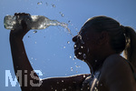 24.06.2026, Sommerhitze in Deutschland, Mindelheim im Unterallgäu, eine Frau erfrischt sich mit einem schwall kaltem Wasser in ihr Gesicht. (Modelrelased)  