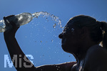 24.06.2026, Sommerhitze in Deutschland, Mindelheim im Unterallgäu, eine Frau erfrischt sich mit einem schwall kaltem Wasser in ihr Gesicht. (Modelrelased)  