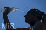 24.06.2026, Sommerhitze in Deutschland, Mindelheim im Unterallgäu, eine Frau erfrischt sich mit einem schwall kaltem Wasser in ihr Gesicht. (Modelrelased)  