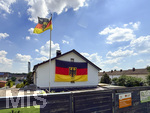 26.06.2026, Fussball WM 2026, Stimmungs-Bilder aus Deutschland. An einem Wohnhaus in Kaufbeuren (Bayern) hängt eine riesige Deutschlandfahne an der Hauswand und am Fahnenmast auch eine Deutsche Landesflagge. 