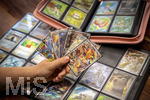 05.08.2026, Deutschland, Bayern, Pokemon-Sammelkarten, eine Teenagerin sammelt begeistert Pokemon-Karten in ihrem Sammelheft.