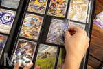 05.08.2026, Deutschland, Bayern, Pokemon-Sammelkarten, eine Teenagerin sammelt begeistert Pokemon-Karten in ihrem Sammelheft.