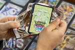 05.08.2026, Deutschland, Bayern, Pokemon-Sammelkarten, eine Teenagerin sammelt begeistert Pokemon-Karten für ihr Sammelheft, eine neue Packung mit Karten wird ausgepackt,